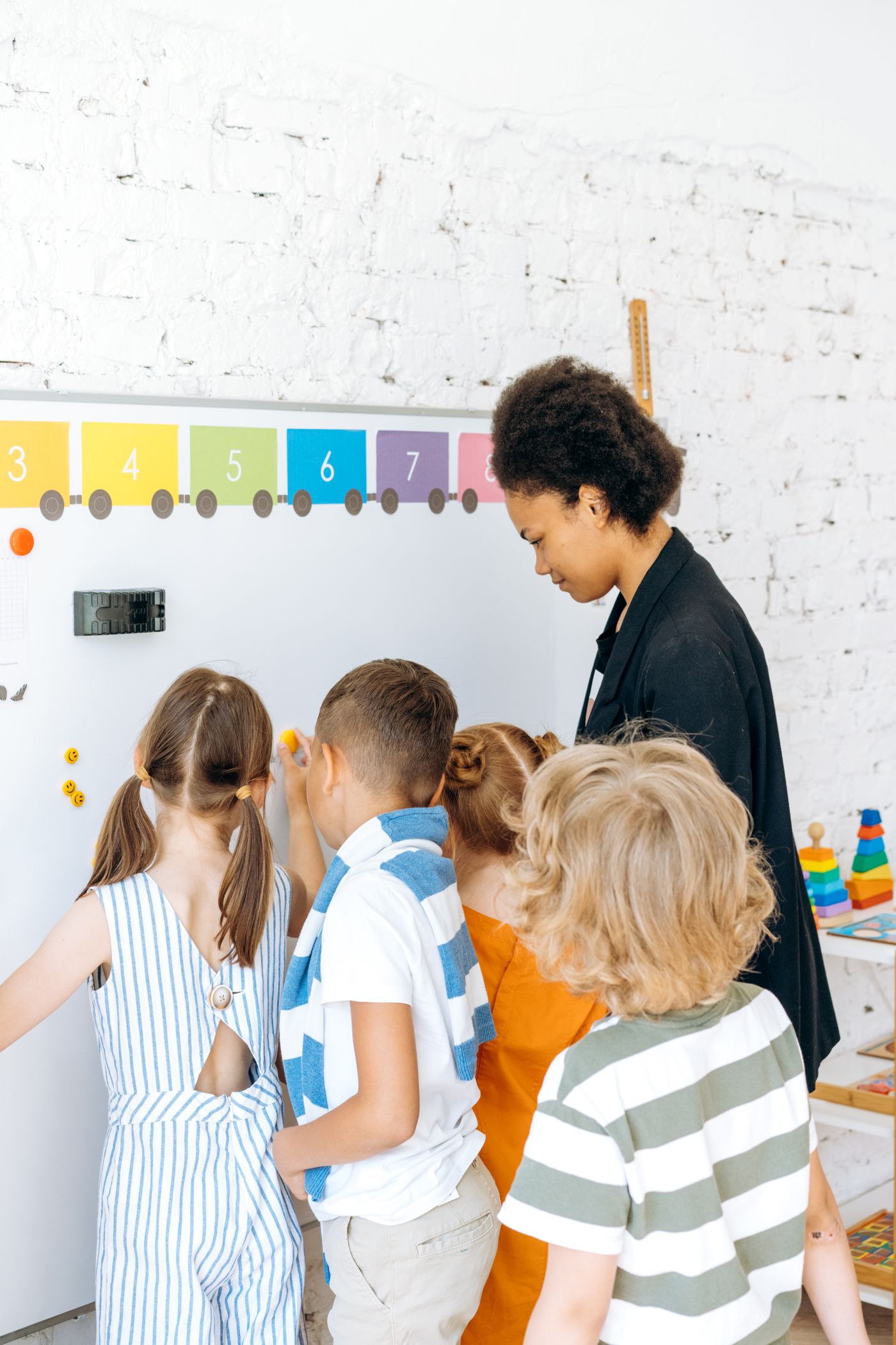 Children learning with a teacher at a whiteboard