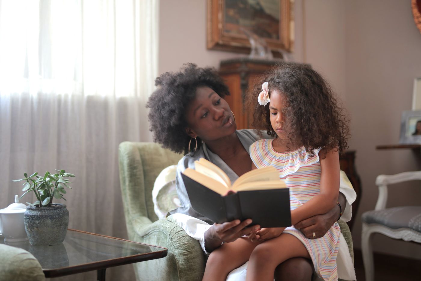 A Black mother and daughter sharing a book