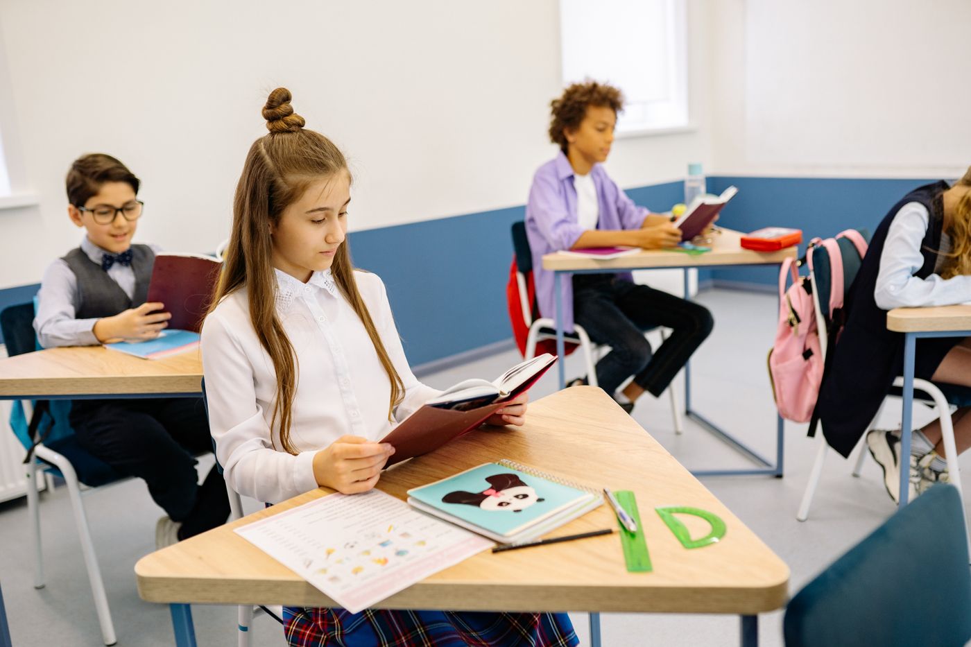 Students exploring a book together in their classroom