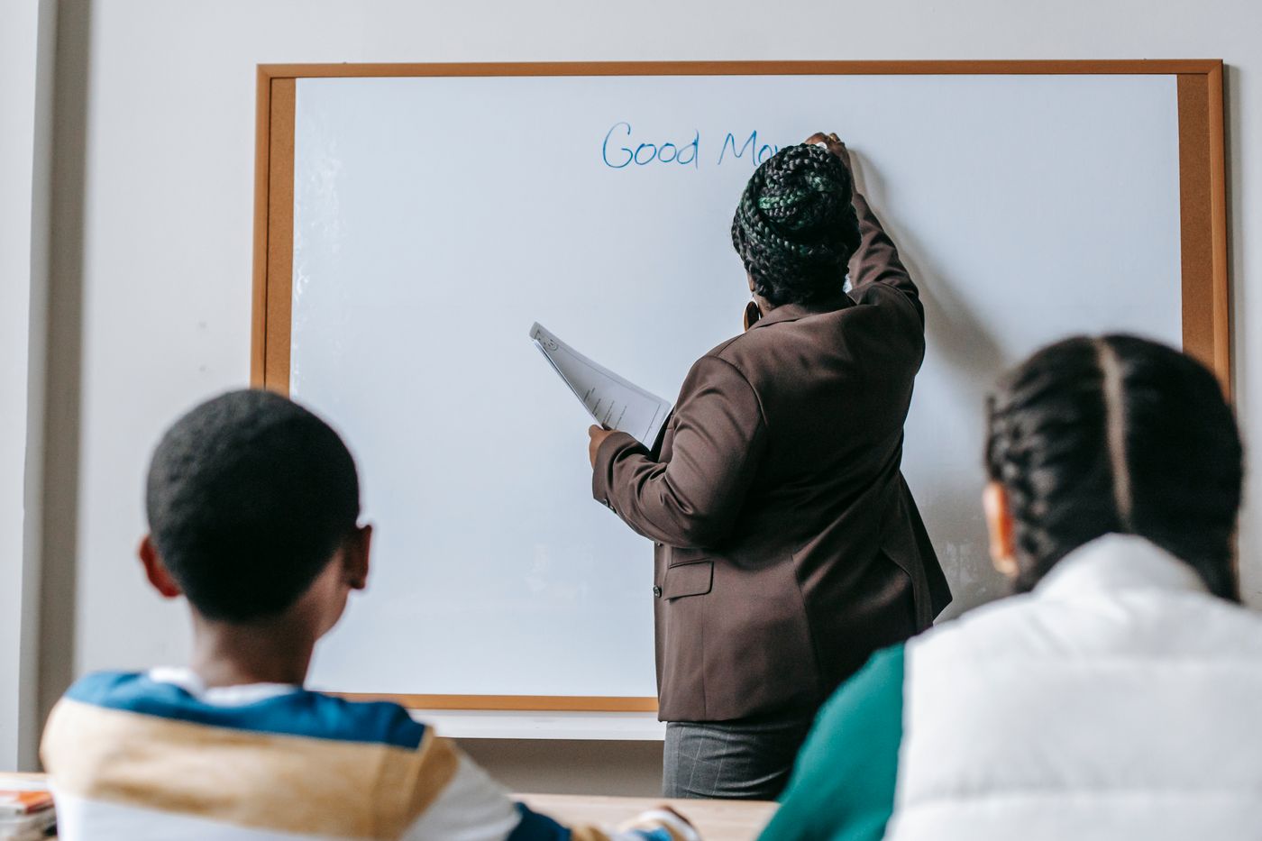 A teacher working at a classroom whiteboard with students